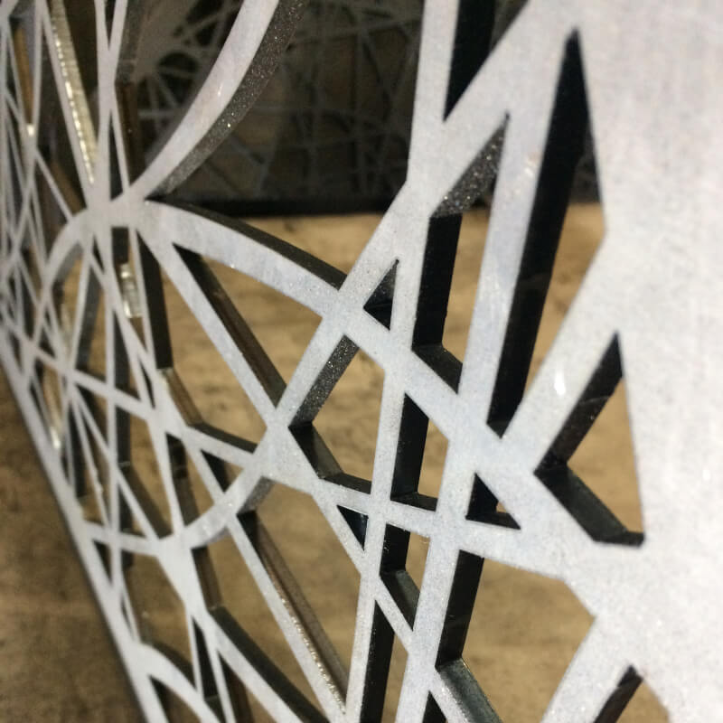 White powder coated laser cut mild steel screen with an abstract pattern