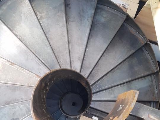 Looking down the plate treads and central column of a steel spiral staircase