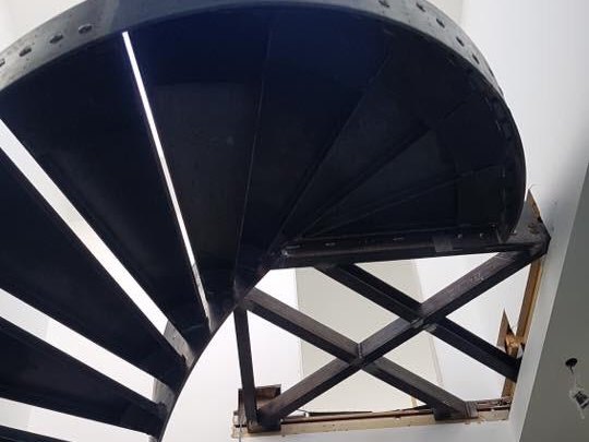 Underside of a black mild steel spiral staircase during installation