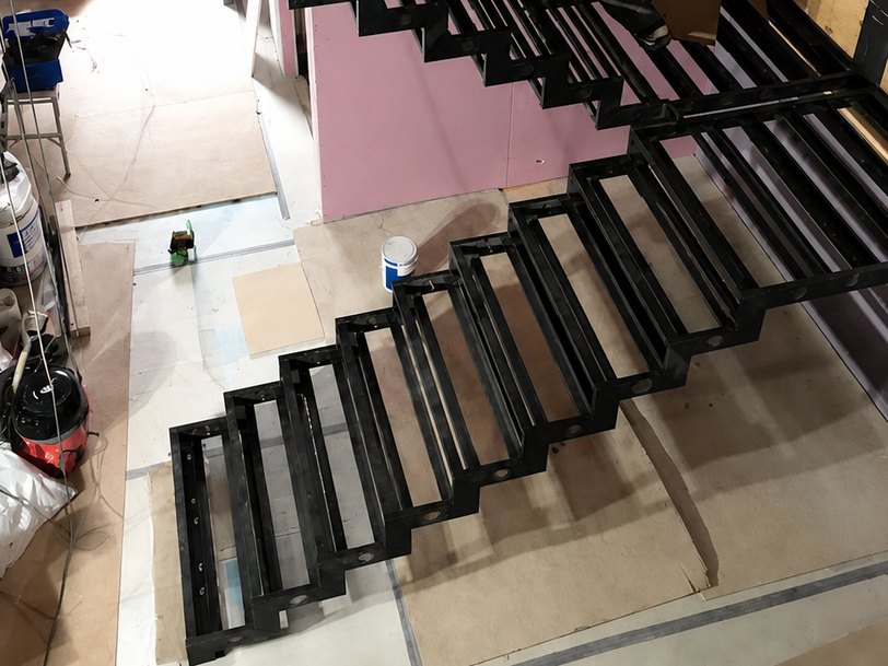 Open tread mild steel staircase frame installed on a fit-out site